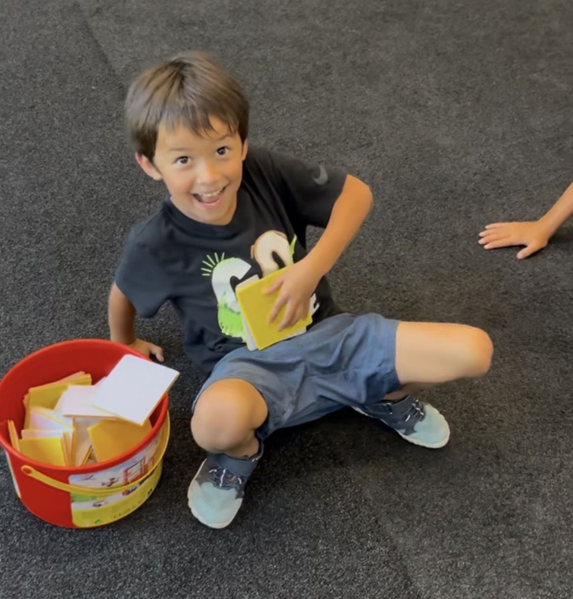 Young boy with activity bucket at Power Play PE preschool class Sacramento