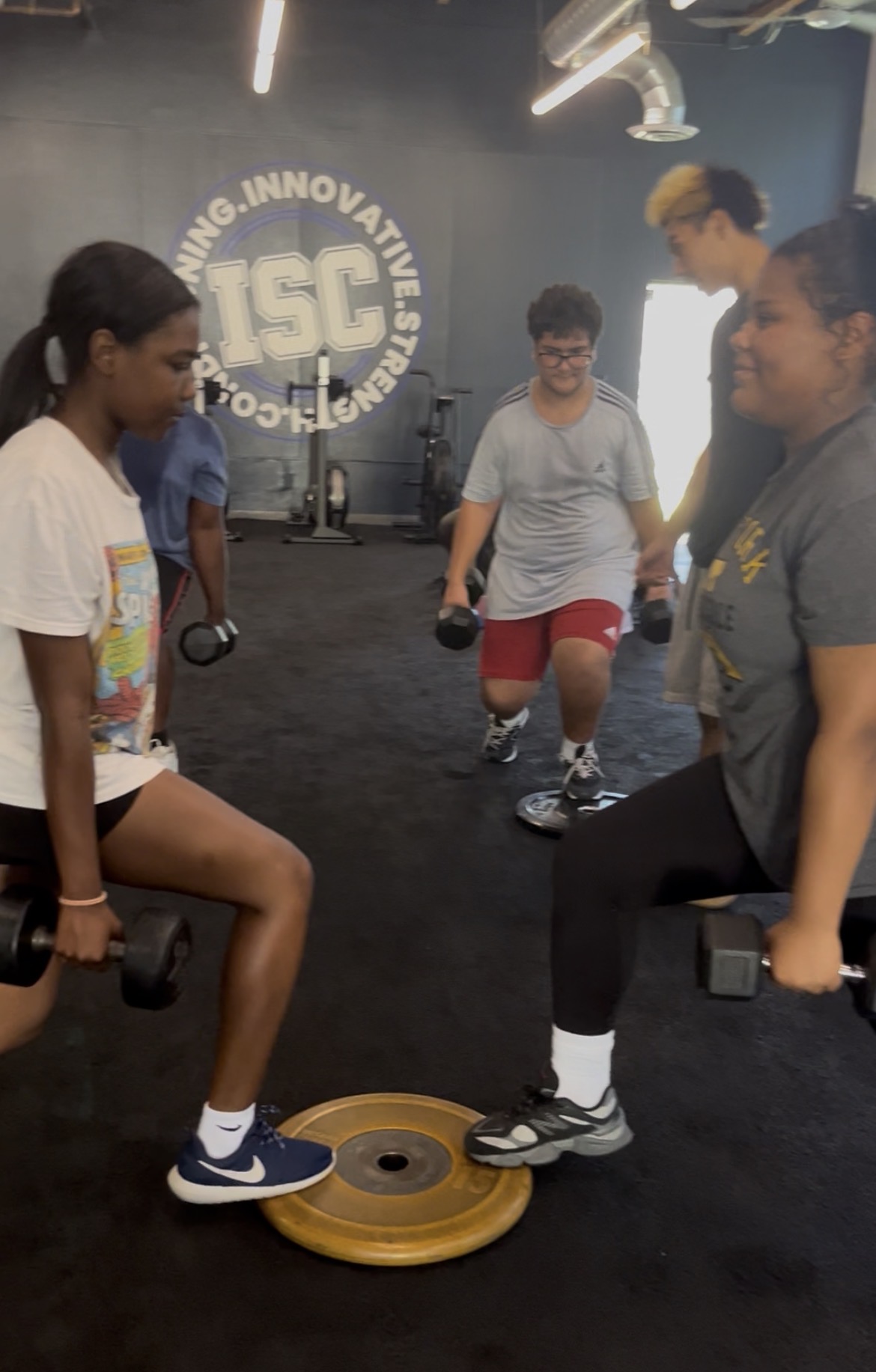 Teens learning dumbbell exercises at Power Play PE Sacramento homeschool gym class