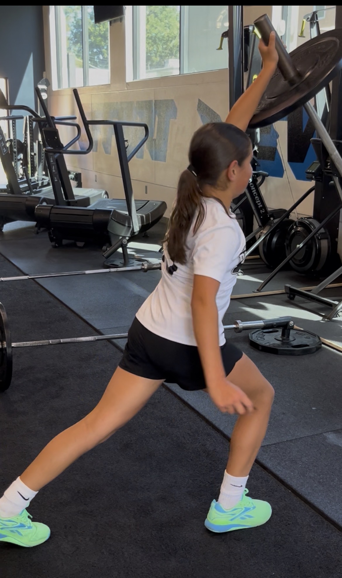 Teen girl doing lunge with plate overhead at ISC Sacramento