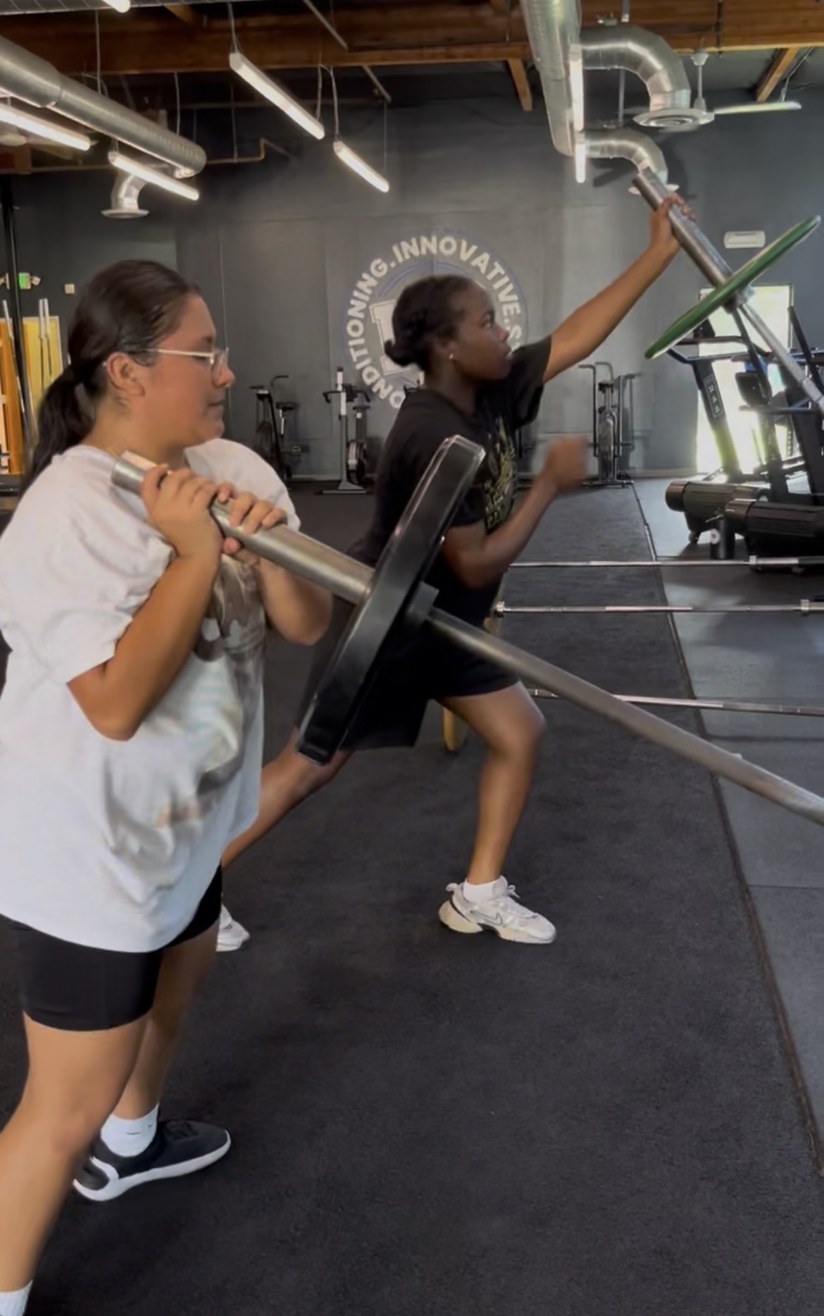 Teen girls learning barbell at Power Play PE Sacramento gym