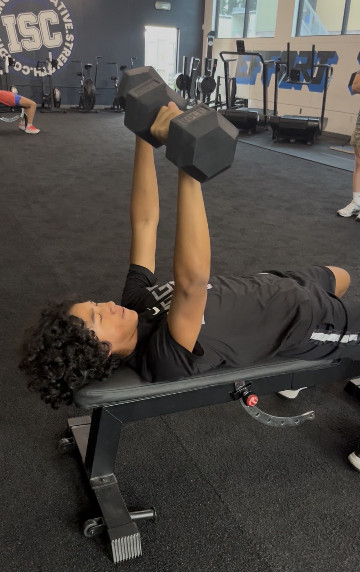 Teen doing dumbbell press on bench at ISC Sacramento