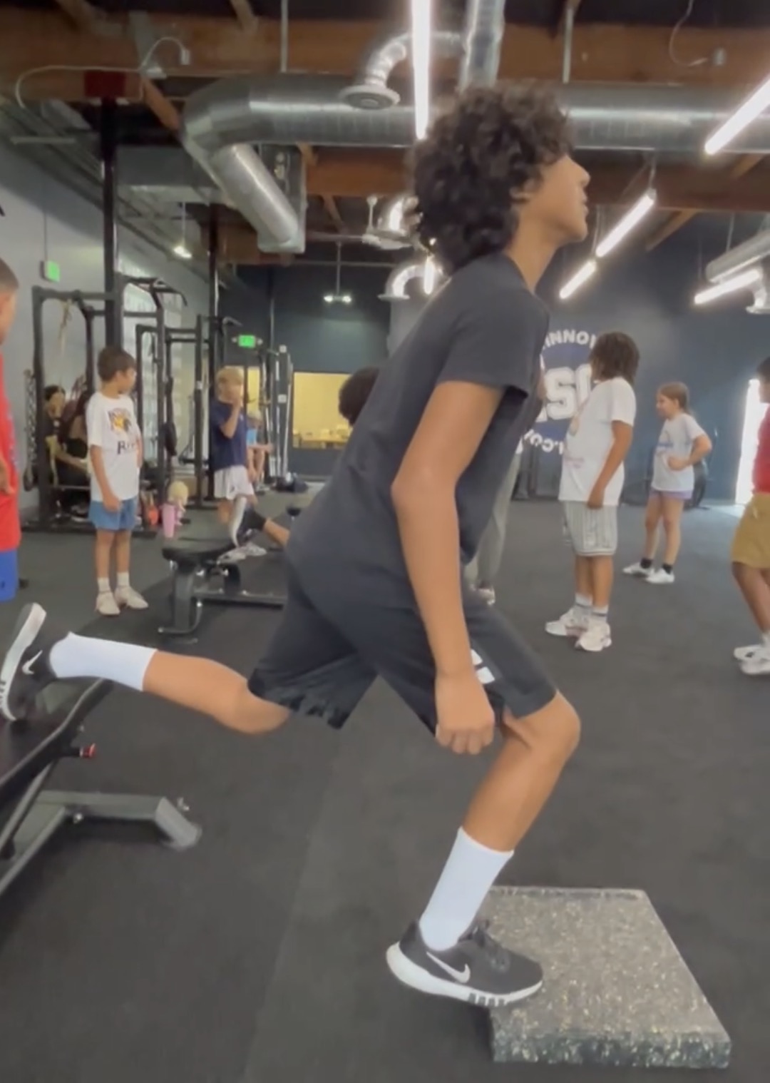Teen doing split squats in the gym at Power Play PE Sacramento